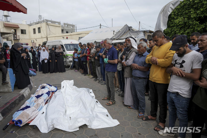 [가자지구=AP/뉴시스] 2일(현지시각) 가자지구 데이르 알발라의 알아크사 병원에서 팔레스타인인들이 이스라엘의 공습으로 숨진 희생자들의 시신을 앞에 두고 기도하고 있다. 2024.05.02
