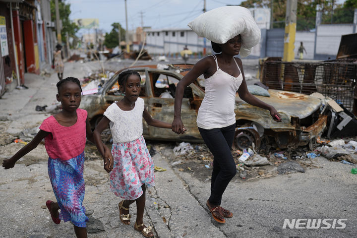 [포르토프랭스=AP/뉴시스] 5월 2일 아이티의 수도 포르토프랭스의 델마22 지역 주민들이 갱단의 폭력을 피해 집을 버리고 대피하고 있다. 2024.05.08.
