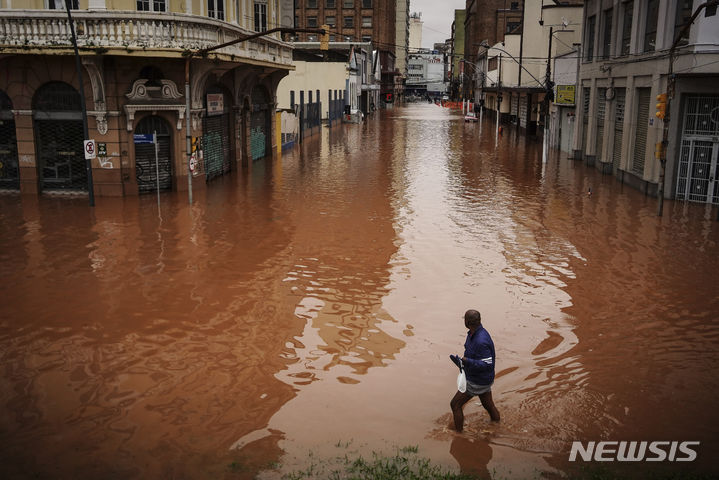 [리우그란데두술=AP/뉴시스] 3일(현지시각) 브라질 남부 리우그란데두술주 포르투 알레그레에서 한 남성이 폭우로 침수된 거리를 걷고 있다. 2024.05.07.