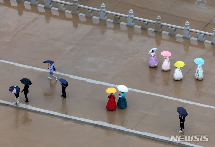 [서울=뉴시스] 배훈식 기자 = 전국에 비가 내린 지난 5일 오후 서울 종로구 광화문 월대에서 우산을 쓴 관광객들이 기념사진을 찍고 있다. 2024.05.05. dahora83@newsis.com