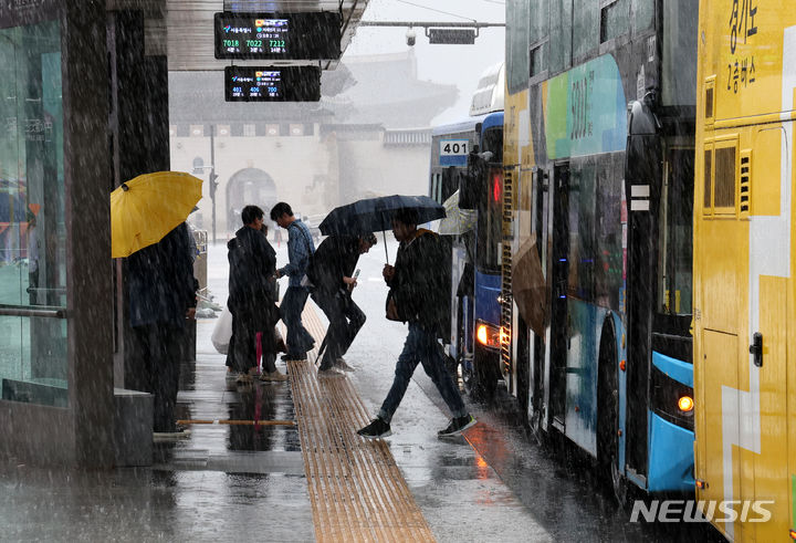 [서울=뉴시스] 배훈식 기자 = 전국에 많은 비가 내린 5일 오후 서울 종로구 광화문 광장에서 우산을 든 시민들이 버스를 타고 있다. 2024.05.05. dahora83@newsis.com