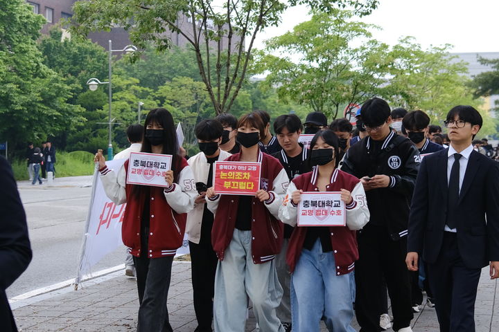 충북대학교 학생자치기구인 중앙운영위원회 구성원들이 7일 대학 내에서 손 팻말을 들고 새 교명 공모를 반대하는 거리 행진을 하고 있다.(사진=충북대 학생자치회 제공).2024.05.07.photo@newsis.com