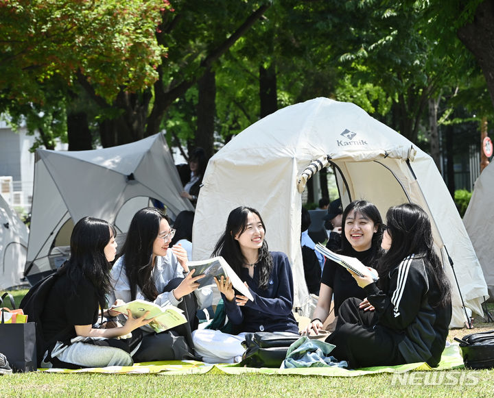 [수원=뉴시스] 김종택기자 = 9일 경기도 수원시 성균관대학교 자연과학캠퍼스 잔디밭에서 '북 피크닉' 행사에 참여한 학생들이 이야기를 나누며 책을 읽고 있다. 2024.05.09. jtk@newsis.com