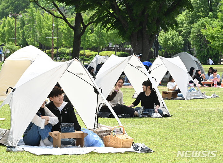 [수원=뉴시스] 김종택기자 = 9일 경기도 수원시 성균관대학교 자연과학캠퍼스 잔디밭에서 '북 피크닉' 행사에 참여한 학생들이 이야기를 나누며 책을 읽고 있다. 2024.05.09. jtk@newsis.com