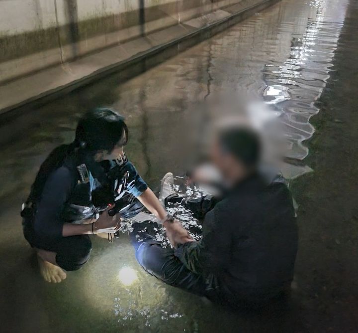[서울=뉴시스] 지하 배수로에 추락한 시민을 구조하기 위해 맨발로 물길을 거슬러 올라간 경찰관의 모습이 공개돼 화제가 됐다. (사진=경찰청 유튜브) *재판매 및 DB 금지