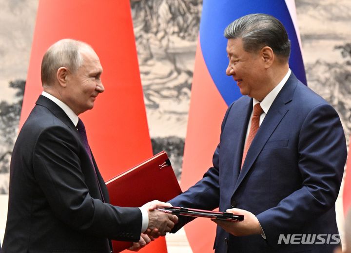 [베이징=AP/뉴시스] 블라디미르 푸틴(왼쪽) 러시아 대통령과 시진핑 중국 국가 주석이 16일 중국 베이징에서 회담 중 서명한 문서를 교환하면서 악수하고 있다. 2024.05.16.