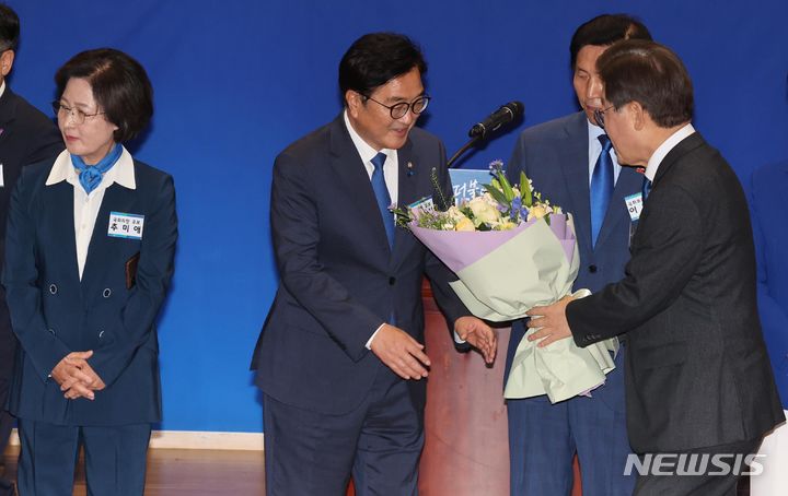 [서울=뉴시스] 권창회 기자 = 22대 국회 전반기 국회의장 후보로 선출된 우원식 더불어민주당 의원이 16일 오전 서울 여의도 국회 의원회관에서 열린 제22대 국회 전반기 국회의장단 후보 선출 당선자 총회에서 이재명 대표에게 꽃다발을 받고 있다. 2024.05.16. kch0523@newsis.com