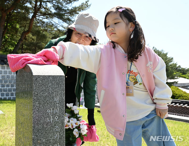 [광주=뉴시스] 박기웅 기자 = 5·18민주화운동 44주기를 이틀 앞둔 16일 오전 광주 북구 운정동 국립5·18민주묘지에서 북구 효령노인복지타운 어르신들과 연제어린이집 아이들이 무명열사 묘역을 찾아 묘비를 닦고 있다. 2024.05.16. pboxer@newsis.com