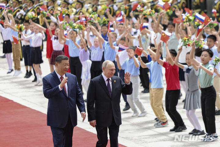 [베이징=AP/뉴시스] 신화통신이 공개한 사진에서 블라디미르 푸틴 러시아 대통령, 시진핑 중국 국가주석이 16일 중국 베이징 인민대회당에서 열린 환영식에서 손을 흔들며 인사하고 있다. 2024.05.17.