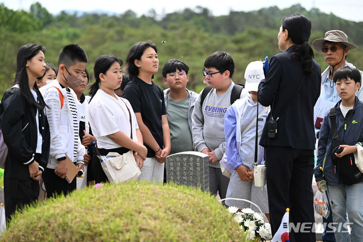 [광주=뉴시스] 이영주 기자 = 5·18민주화운동 44주기를 하루 앞둔 17일 오전 광주 북구 운정동 국립5·18민주묘지에서 학생들이 해설사의 설명을 듣고 있다. 2024.05.17. leeyj2578@newsis.com