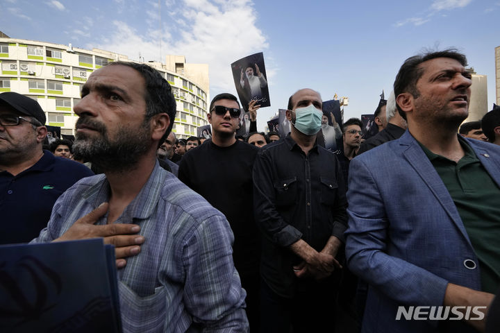 [테헤란=AP/뉴시스] 20일(현지시각) 이란 테헤란의 발리-에-아스르 광장에 모인 시민들이 에브라힘 라이시 대통령을 애도하고 있다. 라이시 대통령은 아미르 압돌라히안 외무장관 등과 함께 19일 헬리콥터 추락 사고로 사망했으며 장례식은 오는 23일 그의 고향인 북동부 마슈하드에서 열릴 것으로 알려졌다. 2024.05.21.