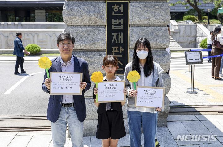 [서울=뉴시스] 정병혁 기자 = 청소년·시민·아기 기후소송 대표자들이 21일 서울 종로구 헌법재판소 앞에서 열린 기후 헌법소원 마지막 공개변론에 앞서 기후 헌법소원 최후진술문을 들고 있다. 2024.05.21. jhope@newsis.com