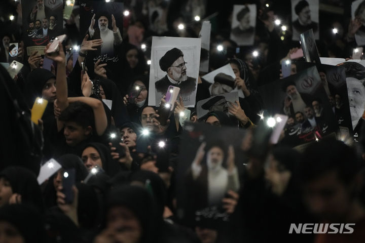 [테헤란=AP/뉴시스] 지난 21일(현지시각) 이란 수도 테헤란 맘 호메이니 그랜드 모스크에서 열린 고 에브라힘 라이시 대통령과 헬기 추락 사고 희생자들의 장례식에 참석한 추모객들이 라이시 대통령의 포스터를 들고 있다. 2024.05.23.