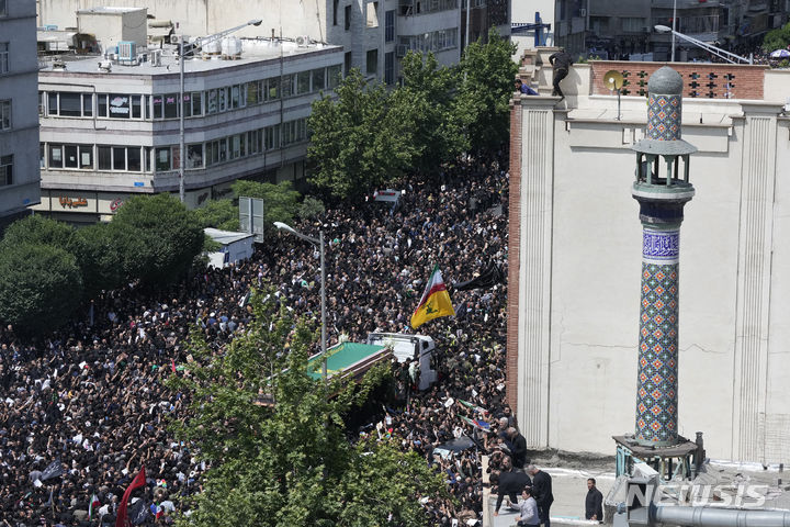 [테헤란=AP/뉴시스] 22일(현지시각) 이란 수도 테헤란에서 고 에브라힘 라이시 대통령과 헬기 추락 사고 희생자들의 장례식이 열려 수많은 사람이 운구 차량을 따라가고 있다. 고인들을 추모하는 수만 인파가 테헤란을 통과하는 운구행렬을 따른 것으로 알려졌다. 2024.05.22.