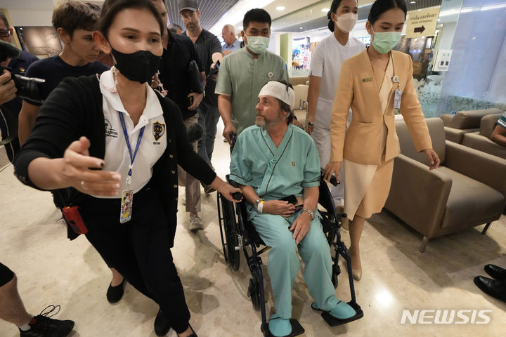 [AP/뉴시스] 난기류 비행 중 머리를 다틴 싱가포르항공의 호주 승객이 23일 방콕 병원에서 취재진과 말하고 있다