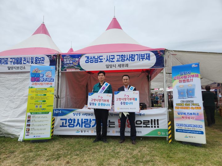 [밀양=뉴시스] 밀양아리랑대축제장에서 시청 최두희 세무담당과 이상훈 농협중앙회 밀양시지부장이 고향사랑기부제 홍보를 하고 있다. (사진=밀양시 제공) 2024.05.27. photo@newsis.com *재판매 및 DB 금지