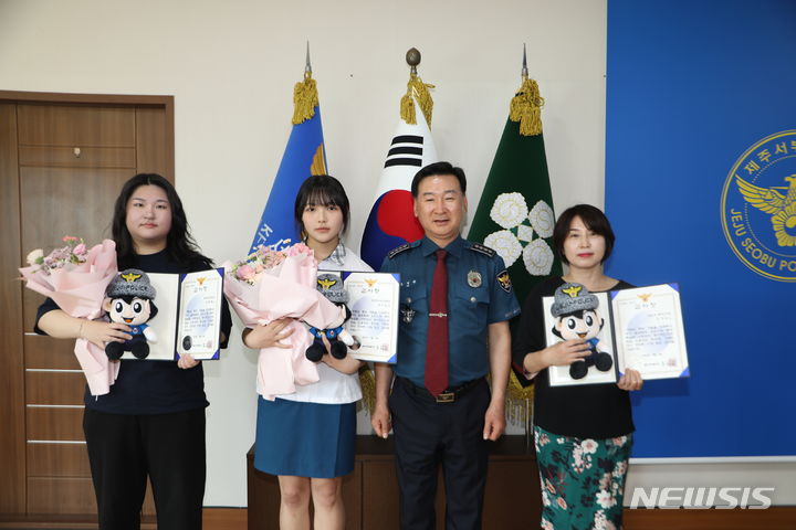 [제주=뉴시스] 제주중앙여고 1학년 정영채·조서원 양이 27일 제주서부경찰서에서 감사장을 받고 기념 사진을 찍고 있다. (사진=제주서부경찰서 제공) 2024.05.28. photo@newsis.com