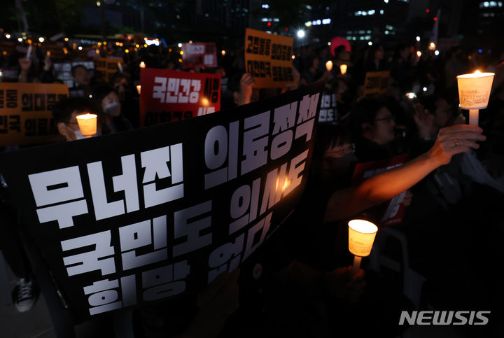 [서울=뉴시스] 이영환 기자 = 30일 오후 서울 중구 덕수궁 대한문 앞에서 대한의사협회가 주최한 대한민국정부, 한국의료 사망선고 촛불집회에서 참석자들이 피켓과 촛불을 들고 있다. 2024.05.30. 20hwan@newsis.com