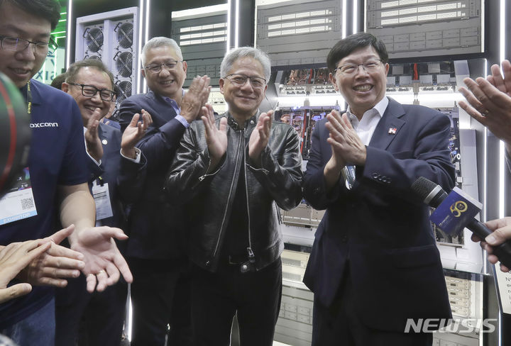 President and CEO of Nvidia Corporation Jensen Huang, center, cheers with Foxconn Chairman Young Liu, right, during the Computex Taipei, one of the world's largest computer and technology expos, in Taipei, Taiwan, Tuesday, June 4, 2024. Computex will run until June 7. (AP Photo/Chiang Ying-ying)