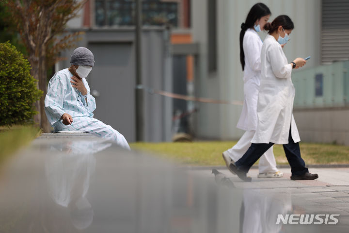 [서울=뉴시스] 김명년 기자 = 서울대학교 의과대학 교수들이 오는 17일부터 응급·중환자실을 제외하고 전체 휴진을 결정한 가운데 7일 오후 서울 종로구 서울대학교병원에서 한 환자가 야외의자에 앉아 있다. 2024.06.07. kmn@newsis.com