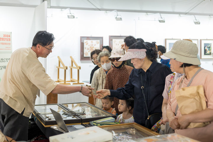 강릉 단오장에 마련된 강릉무형유산관을 방문한 관광객이 전시품을 둘러보고 있다. 강릉단오제 위원회 제공 *재판매 및 DB 금지