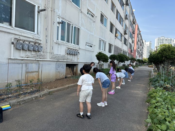 [당진=뉴시스] 지난 11일 2번째 운영에 들어간 당진시 건강한 돌봄 놀이터 프로그램에 참가한 신평면 거산지역아동센터 돌봄교실 아이들이 센터 뒷편에서 교사의 시범에 따라 체조를 하고 있다. (사진=당진시 제공) 2024.06.13. *재판매 및 DB 금지