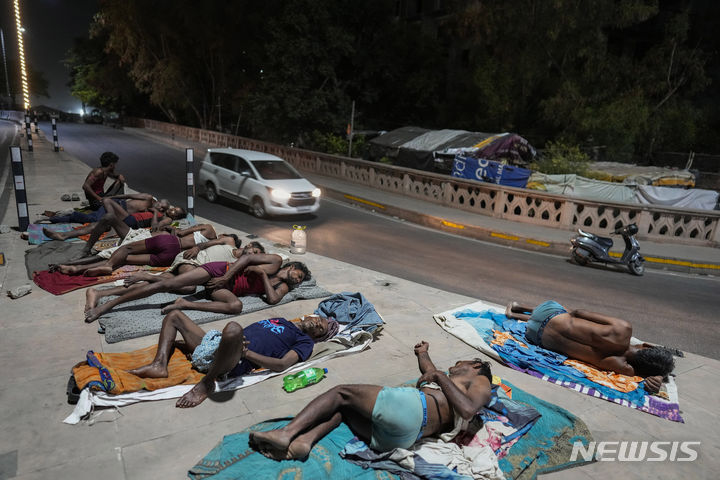 [러크나우=AP/뉴시스] 더운 날씨를 보인 14일 인도 러크나우의 한 길가에서 노동자들이 잠을 자고 있다. 2024.06.17.