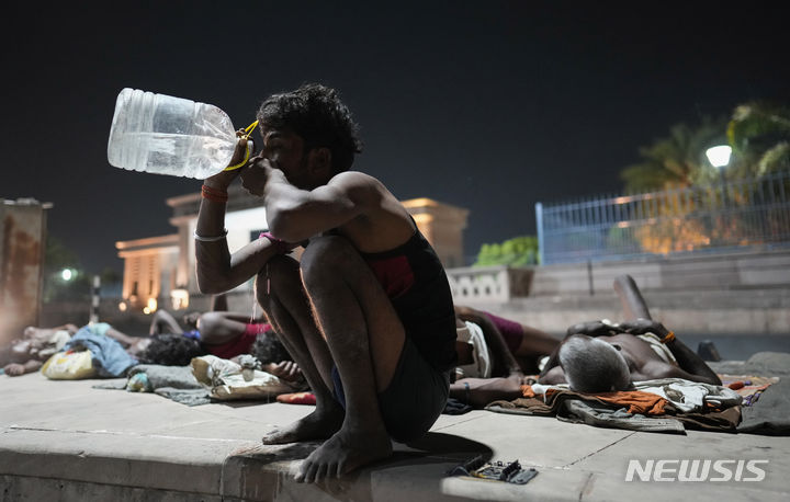 [러크나우=AP/뉴시스] 더운 날씨를 보인 14일 인도 러크나우의 한 길가에서 노동자가 물을 마시고 있다. 2024.06.17.