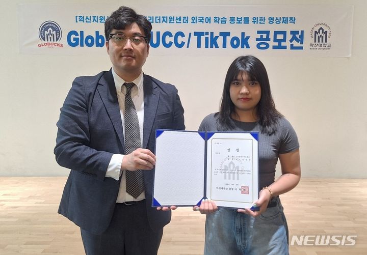 [창원=뉴시스]14일 오후 마산대학교 교내 창의관 1층 특설무대에서 열린 'Globucks UCC & TikTok 공모전' 시상식에서 우수상을 받은 글로벌한국어문화과 까오티빛쩐(오른쪽) 학생이 조현준 글로벌리더지원센터장과 기념촬영하고 있다.(사진=마산대학교 제공) 2024.06.14. photo@newsis.com