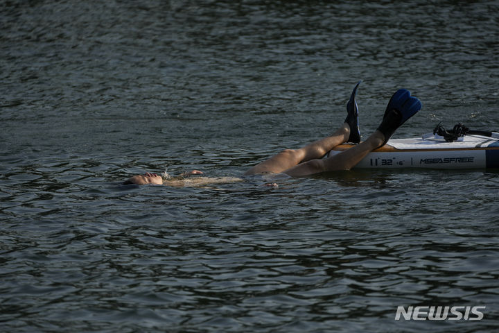 [베이징=AP/뉴시스] 더운 날씨를 보인 16일 중국 베이징의 한 호수에서 남성이 수영을 하고 있다. 2024.06.17.