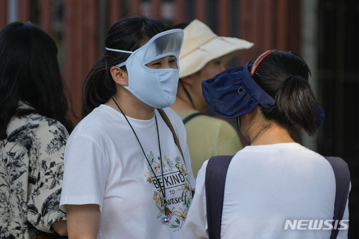 [베이징=AP/뉴시스] 더운 날씨를 보인 16일 중국 베이징에서 한 여성이 자외선 차단용 마스크를 쓰고 있다. 2024.06.17.