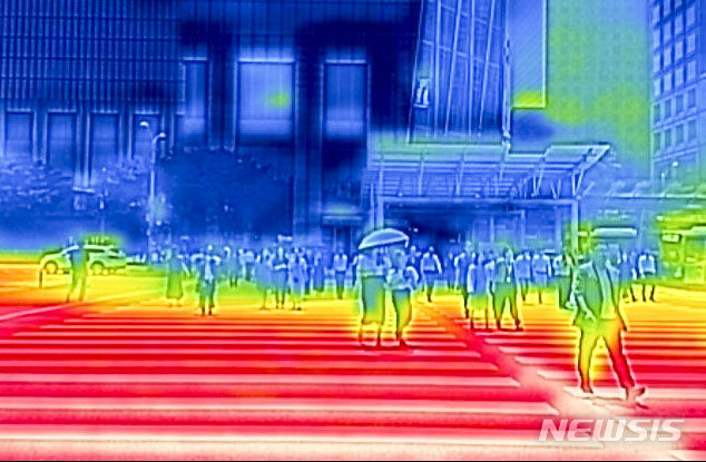 [서울=뉴시스] 정병혁 기자 = 서울을 비롯한 대부분의 지역에 폭염주의보가 발령된 지난달 19일 서울 영등포구 여의도환승센터에서 열화상카메라로 촬영한 횡단보도가 붉게 보이고 있다. 2024.06.19. jhope@newsis.com