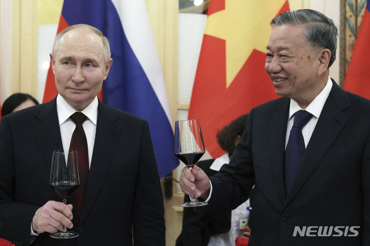 [하노이=AP/뉴시스] 블라디미르 푸틴 러시아 대통령(왼쪽)이 20일 베트남 하노이에서 가진 갈라 행사에서 또 럼 국가주석과 포도주 잔을 기울이고 있다. (사진 크렘린궁 사진 풀) 2024.06.21.