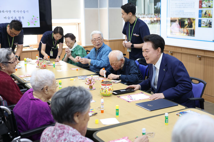 [서울=뉴시스] 최진석 기자 = 윤석열 대통령이 21일 경기 수원시 장안구 수원보훈요양원 내 프로그램실에서 열린 나라사랑 액자만들기 프로그램에 참여하며 어르신들에게 인사하고 있다. (사진=대통령실 제공) 2024.06.21. photo@newsis.com *재판매 및 DB 금지