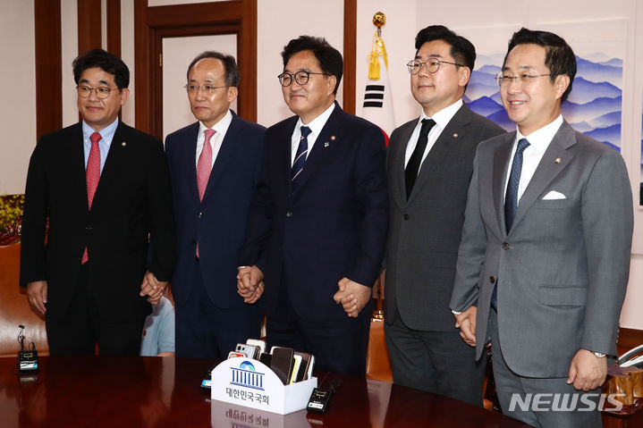 [서울=뉴시스] 고승민 기자 = 우원식 국회의장과 여야 원내대표가 21일 오후 서울 여의도 국회 의장실에서 가진 원 구성 관련 회동에서 손을 맞잡고 기념촬영을 하고 있다.  왼쪽부터 국민의힘 배준영 원내수석부대표, 추경호 원내대표, 우 의장, 더불어민주당 박찬대 원내대표, 박성준 원내수석부대표. (공동취재) 2024.06.21. photo@newsis.com