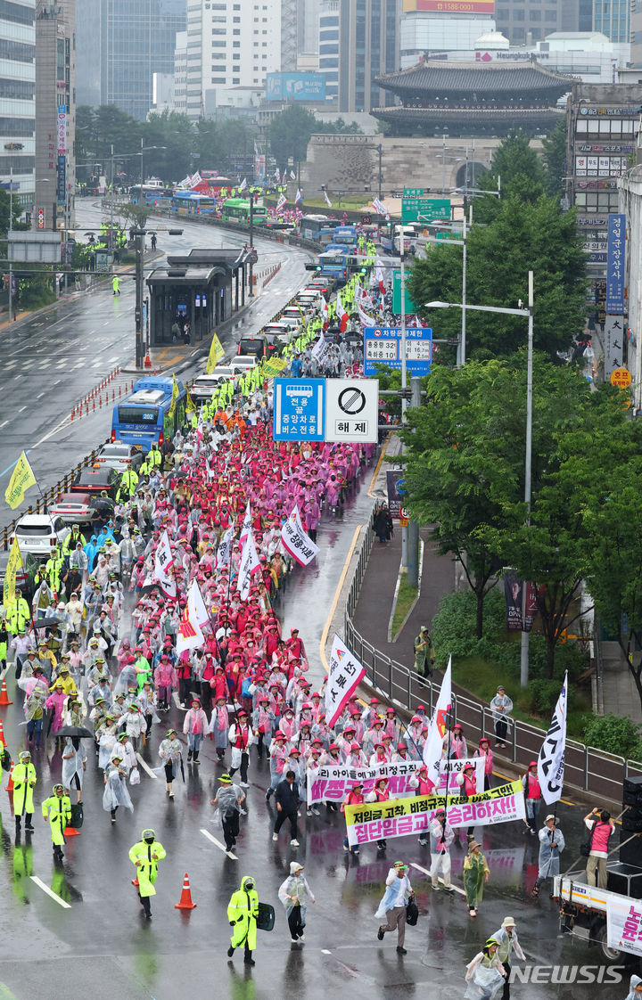 [서울=뉴시스] 전신 기자 = 22일 서울 세종대로에서 열린 전국 노동자 대회에서 전국학교비정규직노동조합 등 민주노총 조합원들이 집회를 마친 뒤 대통령실 청사 방향으로 행진하고 있다. 2024.06.22. photo1006@newsis.com