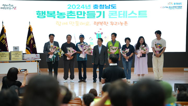 [당진=뉴시스] 지난 20일 '제11회 행복농촌만들기 콘테스트' 농촌만들기 부분에서 최우수상을 수상한 당진시 면천면 활력바라지복지회관을 대표해 박연규 위원장(맨 왼쪽)이 충남도서관에서 꽃다발을 들고 기념 촬영을 하고 있다. (사진=당진시 제공) 2024.06.24. *재판매 및 DB 금지