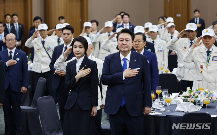 [대구=뉴시스] 최진석 기자 = 윤석열 대통령과 부인 김건희 여사가 25일 대구 북구 엑스코에서 열린 6·25참전영웅 초청 위로연에서 국기에 대한 경례를 하고 있다. 2024.06.25. myjs@newsis.com