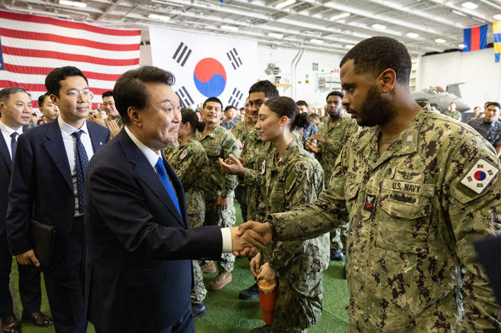 [서울=뉴시스] 최진석 기자 = 윤석열 대통령이 25일 오후 부산 해군작전기지에 정박 중인 미국 시어도어 루즈벨트 항공모함을 방문, 격납고에서 한미장병들에게 격려 발언을 한 뒤 한미장병들과 인사하고 있다. (사진=대통령실 제공) 2024.06.25. photo@newsis.com *재판매 및 DB 금지