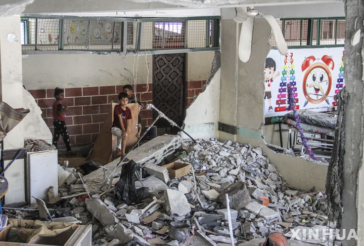 [가자지구=신화/뉴시스] 25일(현지시각) 가자지구 가자시티 서쪽 알샤티 난민촌에서 팔레스타인 어린이들이 이스라엘의 공습으로 파괴된 학교 교실을 살피고 있다. 차치 하네그비 이스라엘 안보보좌관은 이날 가자 북부에서 '하마스 이후' 계획을 곧 실행할 것이라고 밝혔다. 2024.06.26.