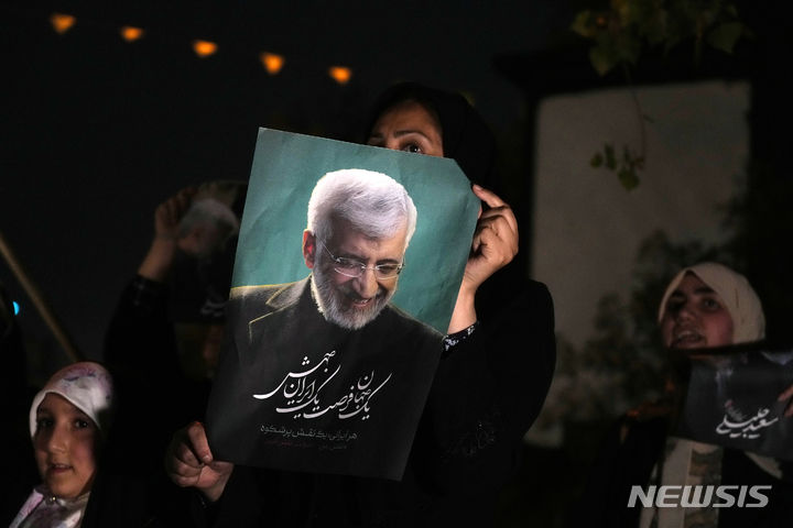 [테헤란=AP/뉴시스] 사이드 잘릴리 이란 대선 후보의 한 여성이 26일(현지시각) 테헤란에서 열린 선거 유세에 참석해 그의 사진을 들고 지지하고 있다. 강경파 후보인 잘릴리 후보는 "경제적 수단을 통해 (서방이) 이란을 제재한 것을 후회하게 만들어야 한다"라고 말했다. 2024.06.27.