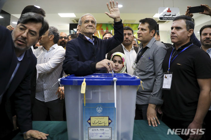 [테헤란=AP/뉴시스] 이란 ISNA가 제공한 사진에 개혁파 후보 마수드 페제시키안이 28일(현지시각) 수도 테헤란 한 투표소에서 투표하며 손을 흔드는 모습. 2024.06.30.