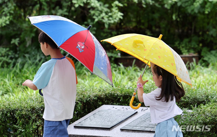 [대구=뉴시스] 이무열 기자 = 전국 대부분 지역이 흐리고 비가 내린 30일 대구 중구 2.28기념중앙공원 인근에서 어린이들이 우산을 쓰고 이동하고 있다. 2024.06.30. lmy@newsis.com