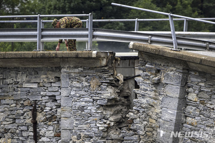 [스위스=AP/뉴시스] 지난달 30일(현지시각) 스위스 남부 마지아 계곡에서 한 군인이 폭풍우로 붕괴된 비슬레토 다리를 살펴보고 있다. 2024.07.01. 