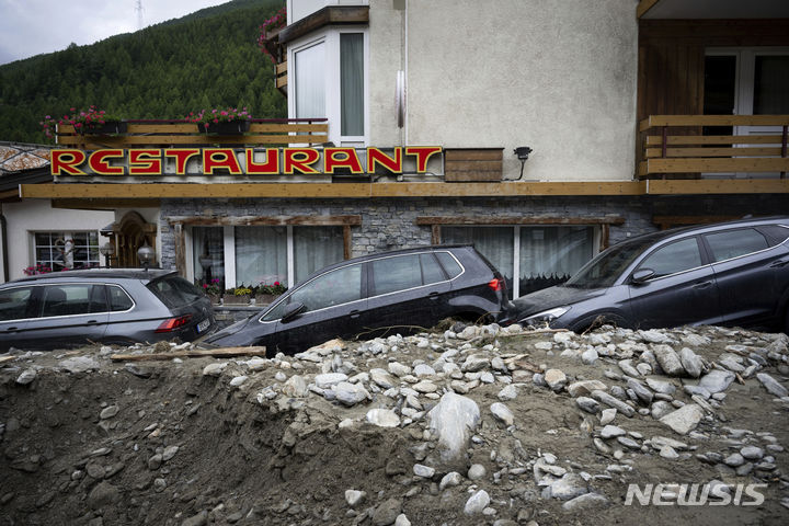 [스위스=AP/뉴시스] 지난달 30일(현지시각) 스위스 사스 그룬드에서 대규모 홍수와 산사태가 발생해 차량이 흙더미에 파묻혀 있다. 2024.07.01.
