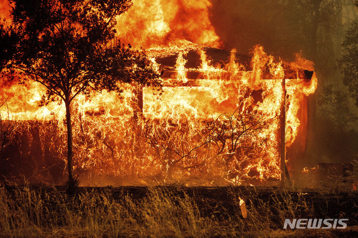 [캘리포니아=AP/뉴시스] 2일(현지시각) 미국 캘리포니아주 오로빌에서 발생한 톰슨 화재로 한 주택이 불에 타고 있다. 2024.07.04.