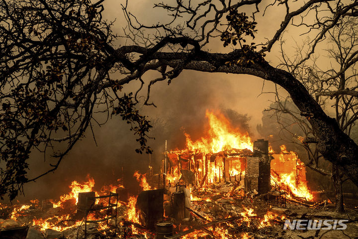 [캘리포니아=AP/뉴시스] 2일(현지시각) 미국 캘리포니아주 오로빌에서 발생한 톰슨 화재로 한 건물이 화염에 휩싸여 있다. 2024.07.04.