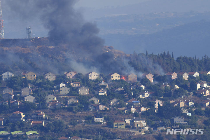 [메툴라(이스라엘)=AP/뉴시스]이스라엘 북부 국경도시 메툴라에서 지난달 22일 레바논 헤즈볼라의 포격으로 불길과 검은 연기가 치솟고 있다. 레바논의 헤즈볼라 그룹은 4일 이스라엘군의 드론 공격으로 헤즈볼라 고위 지휘관 1명이 숨진 공격에 대한 보복으로 이스라엘의 여러 군사기지들에 200발이 넘는 로켓 공격을 가했다고 밝혔다. 2024.07.04.