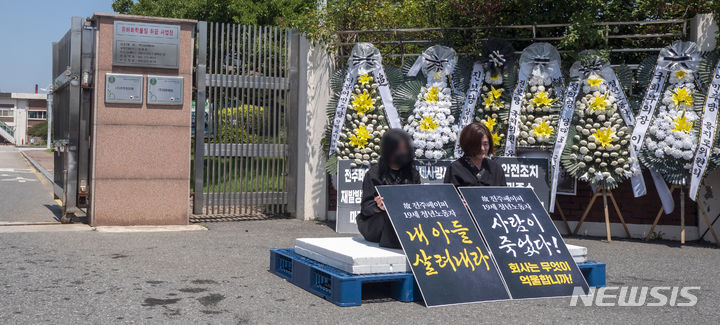 [전주=뉴시스] 강경호 기자 = 4일 전북 전주시 덕진구 팔복동 전주페이퍼 공장 정문 앞에서 전주페이퍼 사망사고 유가족들이 무기한 단식투쟁을 선언 후 정문에서 피켓을 들고 앉아있다. 2024.07.04. lukekang@newsis.com