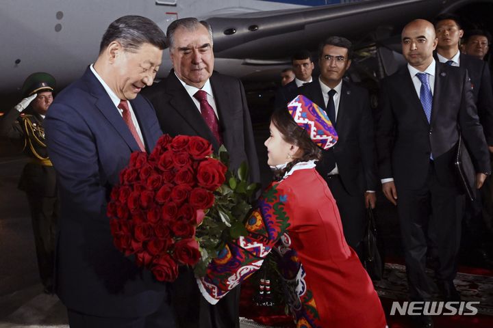 [두샨베=AP/뉴시스] 시진핑(왼쪽) 중국 국가주석이 4일(현지시각) 타지키스탄 수도 두샨베 국제공항에 도착해 에모말리 라흐몬 타지키스탄 대통령이 지켜보는 가운데 한 소녀로부터 환영 꽃다발을 받고 있다. 2024.07.05.